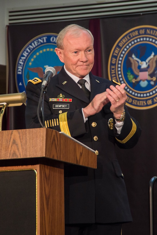 Chairman of the Joint Chiefs of Staff, GEN Martin Dempsey, USA, pays tribute to Mrs. Debbie Alexander and the Alexander family at the retirement ceremony for GEN Keith Alexander, USA, March 28, 2014