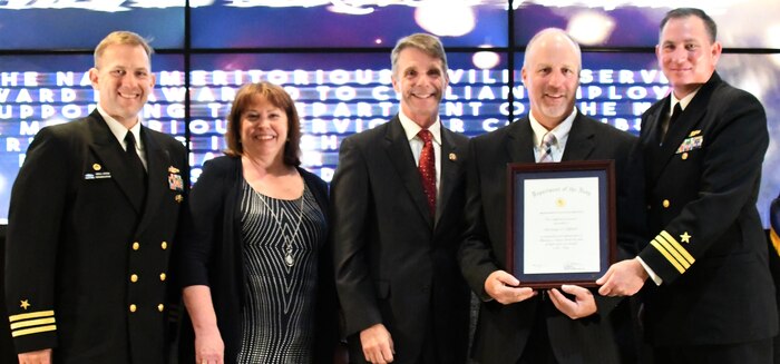 IMAGE: Christian Clifford receives the Navy Meritorious Civilian Service award during the annual honorary awards ceremony, May 10. Standing left to right: NSWCDD Dam Neck Activity Commanding Officer Cmdr. Andrew Hoffman; NSWCDD Deputy Technical Director Angela Beach; U.S. Rep. Rob Wittman; Clifford; and NSWCDD Commanding Officer Cmdr. Stephen ‘Casey’ Plew.