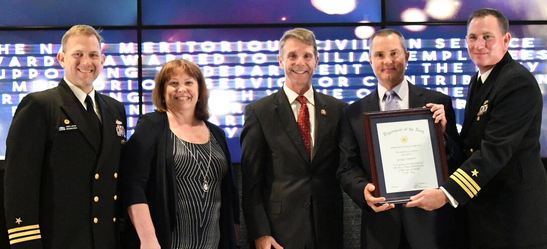 IMAGE: George Clotfelter receives the Navy Meritorious Civilian Service award during the annual honorary awards ceremony, May 10. Standing left to right: NSWCDD Dam Neck Activity Commanding Officer Cmdr. Andrew Hoffman; NSWCDD Deputy Technical Director Angela Beach; U.S. Rep. Rob Wittman; Clotfelter; and NSWCDD Commanding Officer Cmdr. Stephen ‘Casey’ Plew.
