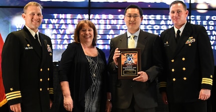 IMAGE: Michael Huang receives the Award of Excellence for  Systems Engineering and Integration at the annual honorary awards ceremony, May 10.  Standing left to right: NSWCDD Dam Neck Activity Commanding Officer Cmdr. Andrew Hoffman; NSWCDD Deputy Technical Director Angela Beach; Huang; and NSWCDD Commanding Officer Cmdr. Stephen ‘Casey’ Plew.