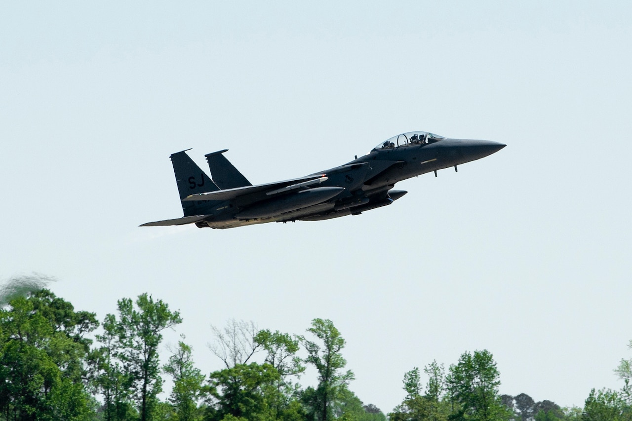 An F-15E Strike Eagle fighter jet flies low.