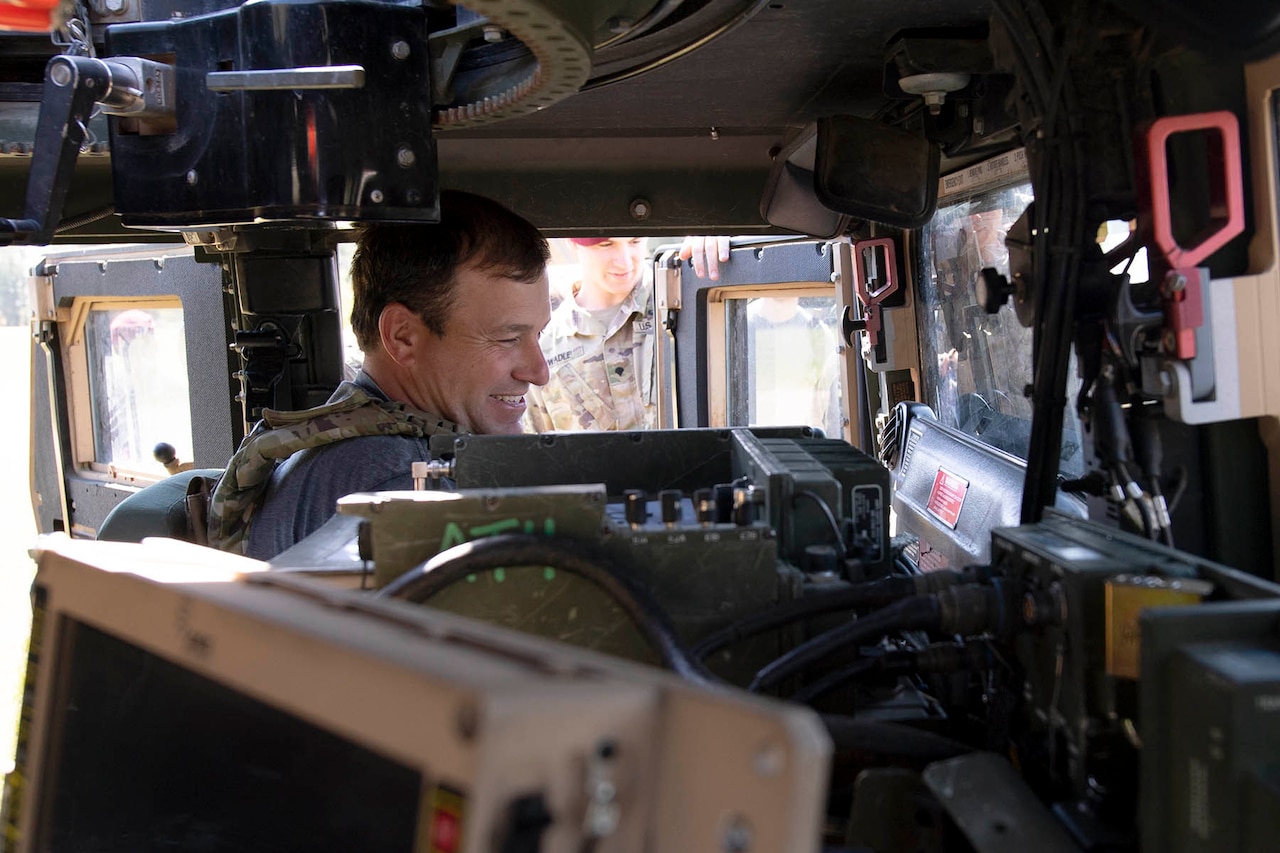 A man sits inside an Army Humvee.