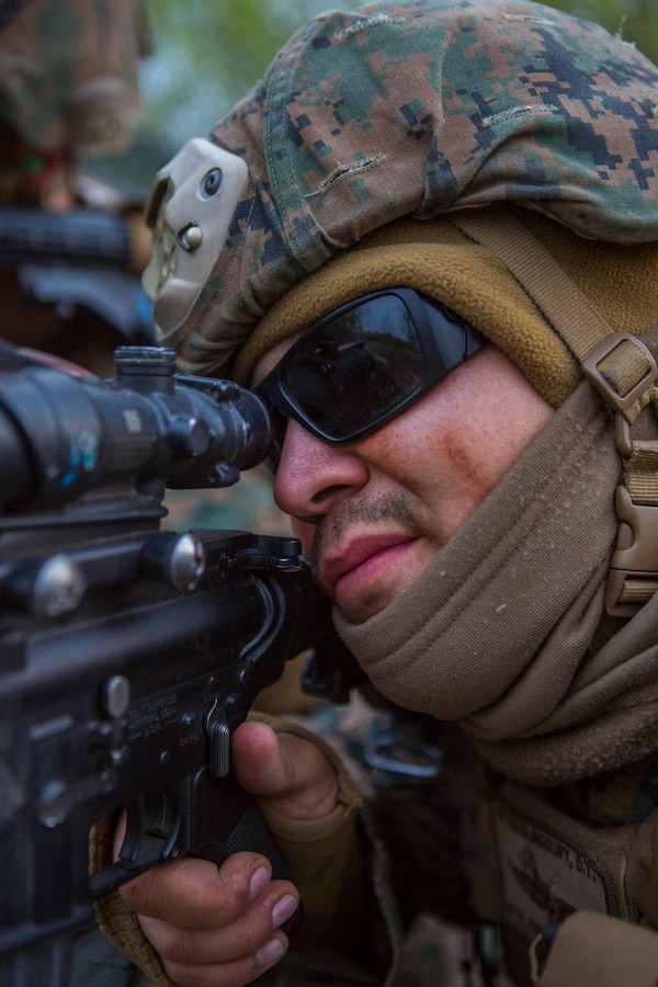 U.S. Marine Corps Lance Cpl. Dawson Ortiz, a radio operator with 6th Air Naval Gunfire Liaison  Company, Force Headquarter Group, Marine Forces Reserve, takes cover behind his Humvee during an ambush of his campsite during exercise Maple Resolve in Camp Wainwright, Alberta, Canada, May 14, 2019. Maple Resolve is an annual exercise, 3-week multinational simulated war, hosted by the Canadian Army bringing NATO allies together from across the world to share and learn tactics while strengthening foreign military ties. (U.S. Marine Corps photo by Cpl. Niles Lee)