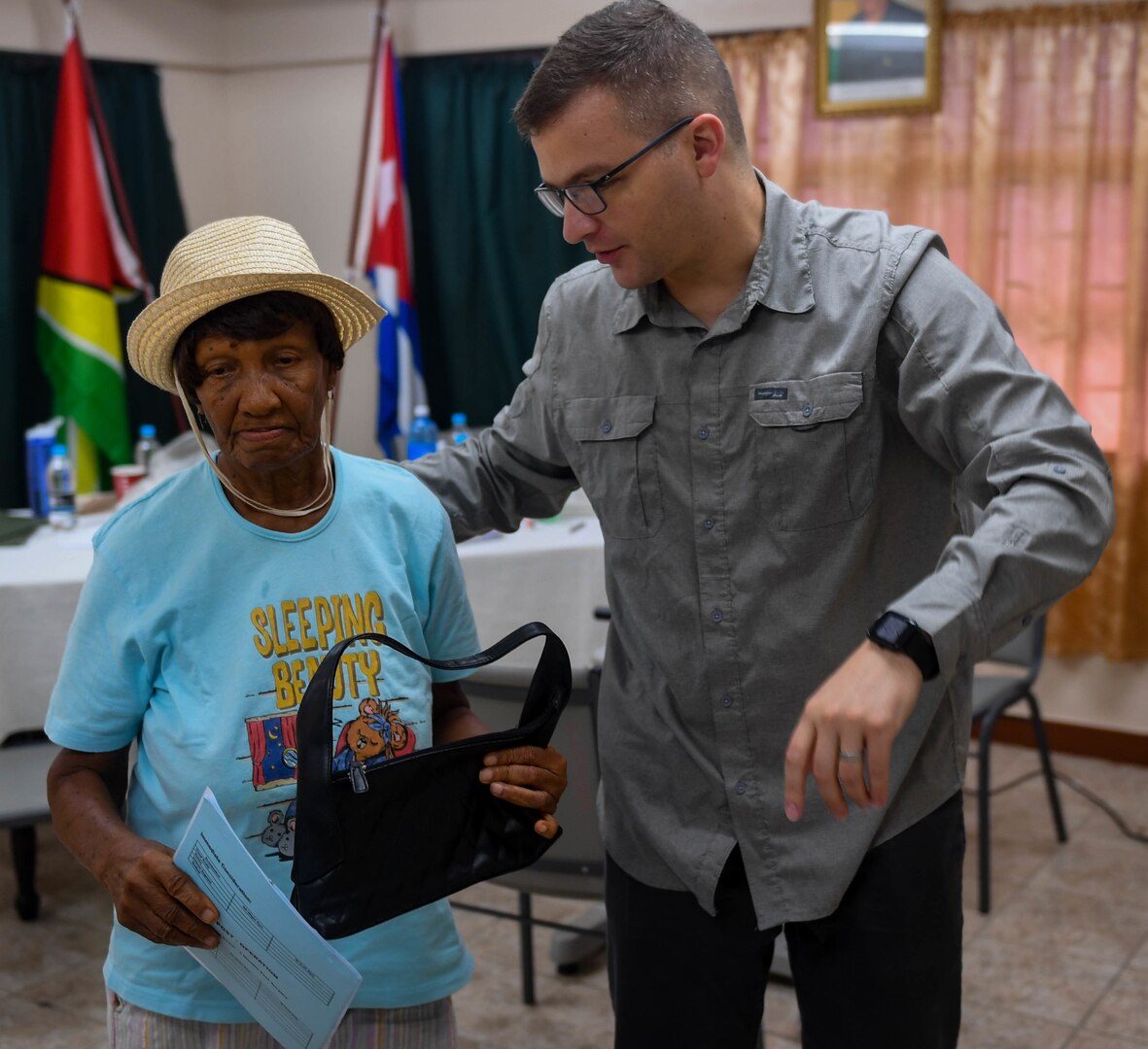 Air Force Maj. Andrew Lewis, ophthalmologist from Joint Base San Antonio-Lackland, guides a Guyanese patient to the next examine station during New Horizons 2019, Port Mourant, Guyana, May 3, 2019. The New Horizons exercise 2019 provides U.S. military members an opportunity to train for an overseas deployment and the logistical requirements it entails. The exercise promotes bilateral cooperation by providing opportunities for U.S. and partner nation military engineers, medical personnel and support staff to work and train side by side.