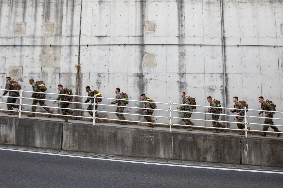 A group of Marines run up a ramp.