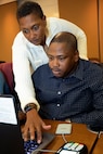 U.S. Army Sgt. 1st Class Cassandra McCulloch, U.S. Army Financial Management Command senior financial management trainer, helps U.S. Army Staff Sgt. Marvin Luke, 4th Financial Management Support Unit disbursing manager, during a USAFMCOM and Federal Reserve Bank of Boston-hosted training session at the Federal Reserve Bank of Boston May 8, 2019.