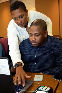 U.S. Army Sgt. 1st Class Cassandra McCulloch, U.S. Army Financial Management Command senior financial management trainer, helps U.S. Army Staff Sgt. Marvin Luke, 4th Financial Management Support Unit disbursing manager, during a USAFMCOM and Federal Reserve Bank of Boston-hosted training session at the Federal Reserve Bank of Boston May 8, 2019.