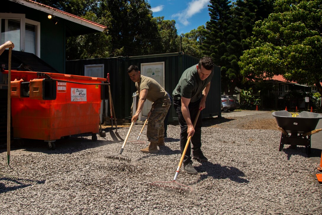 A U.S. Navy Sailor (right) with 2nd Battalion, 3d Marine Regiment, and a U.S. Army Soldier with the 130th Engineer Brigade lay down gravel in part of a community event with the St. James Episcopal Church, Waimea, Hawaii, May 16, 2019. Community events strengthen the relationships with the community surrounding Pohakuloa Training Area and the U.S. military. (U.S. Marine Corps photo by Cpl. Brendan Custer)