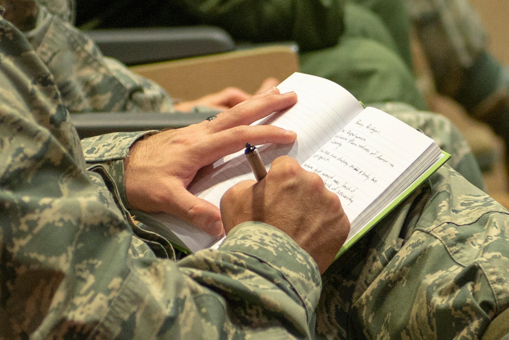 Team Offutt member takes notes during speech presented by retired Air Force Lt. Col Barry Bridger at the commander’s updated briefing May 16, 2019, at Offutt Air Force Base, Nebraska. Bridger is a six-year survivor of Vietnam’s Hoa Loa prisoner of war camp.