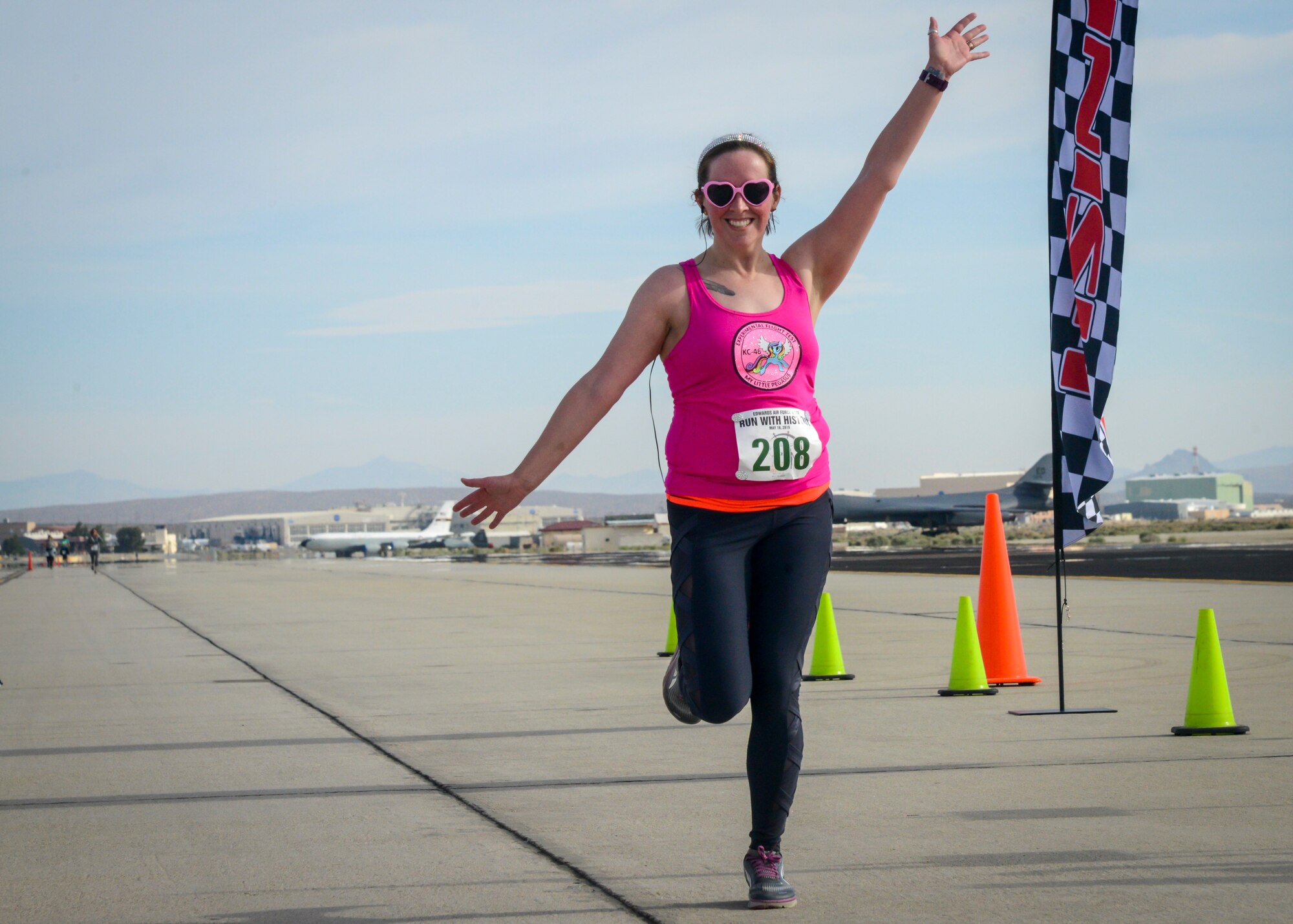 A runner strikes a pose as she crosses the finish line of the Run with History Half Marathon, 10k and 5k at Edwards Air Force Base, Calif., May 18. (U.S. Air Force photo by Giancarlo Casem)