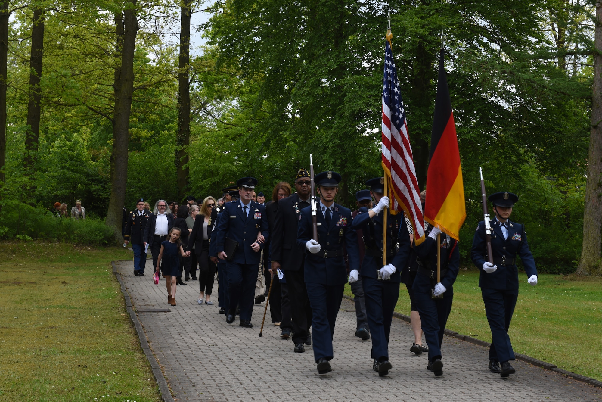 The Ramstein High School Junior Reserve Officers’ Training Corps leads attendees to the Kindergraves at the Kaiserslautern Main Cemetery, Kaiserslautern, Germany, May 19, 2019. The Kindergraves are the final resting place to the 451 children who passed away between 1952 and 1971. (U.S. Air Force photo by Airman 1st Class Kaylea Berry)