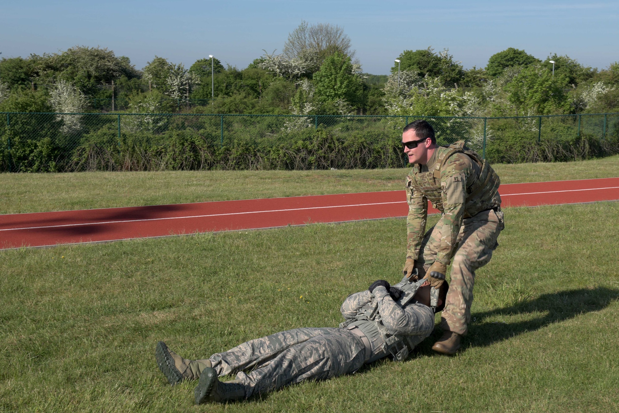 U.S. Air Force Staff Sgt. Brandon Russell, 100th Security Forces Squadron base defense operation center controller, drags Airman 1st Class Nathaniel Chargualaf, 100th SFS response force member, during the Defenders Challenge at RAF Mildenhall, England, May 15, 2019. For the challenge, teams of four competed against each other in a total of 14 different obstacles. (U.S. Air Force photo by Senior Airman Benjamin Cooper)