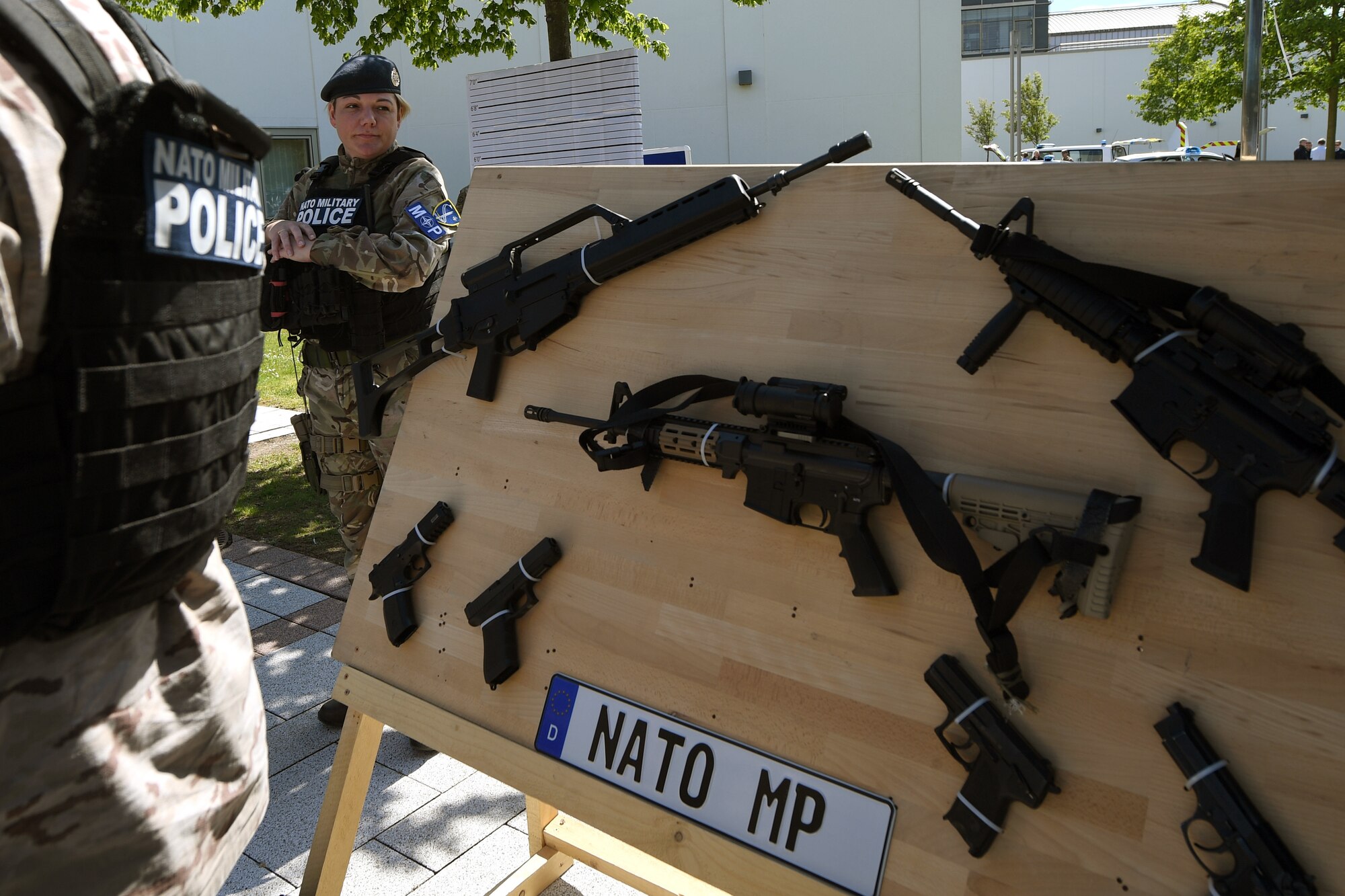 Royal Air Force Cpl. Chantal Gagetta, NATO Military police member, stands next to a gun display during Police Week 2019 on Ramstein Air Base, Germany, May 17, 2019.
