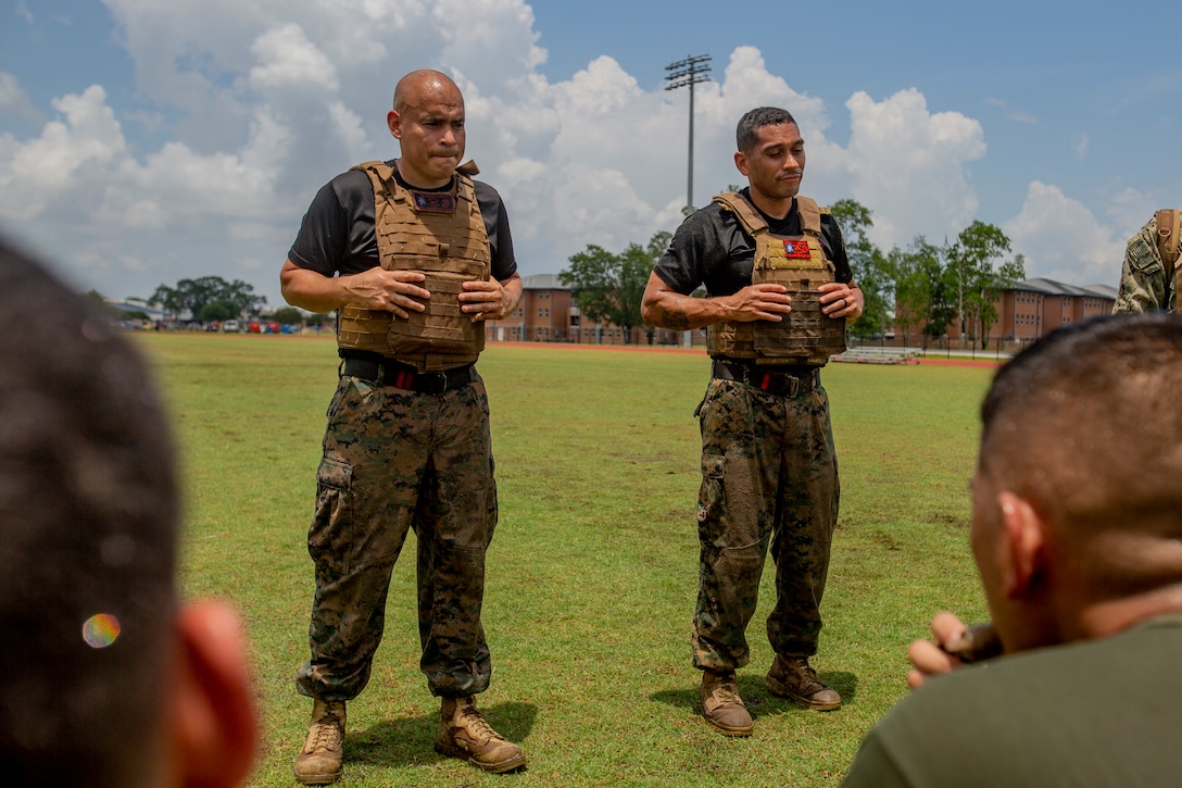 U.S. Marine Corps Staff Sgt. Pedro U. Padilla, left, a chief instructor trainer, and Staff Sgt. David G. Munoz, right, assistant chief instructor trainer both with Marine Aircraft Group 49, 4th Marine Aircraft Wing, Marine Forces Reserve, speak to students with Martial Arts Instructor Course 1-19 after a combat conditioning exercise at Naval Air Station Joint Reserve Base New Orleans on May 20, 2019. To increase readiness and to support the total force, Reserve and active Marines with MARFORRES participate in the Martial Arts Instructor Course.  (U.S. Marine Corps photo by Lance Cpl. Jose Gonzalez)
