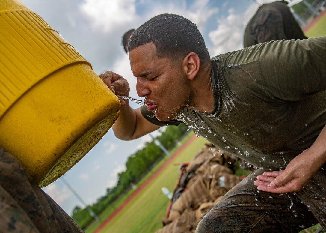 U.S. Marine Corps Cpl. Luis Alicea, a ground support equipment mechanic with Marine Aircraft Group 49, 4th Marine Aircraft Wing, Marine Forces Reserve, drinks water after a combat conditioning exercise at Naval Air Station Joint Reserve Base New Orleans on May 20, 2019. To increase readiness and to support the total force, Reserve and active Marines with MARFORRES participate in the Martial Arts Instructor Course.  (U.S. Marine Corps photo by Lance Cpl. Jose Gonzalez)