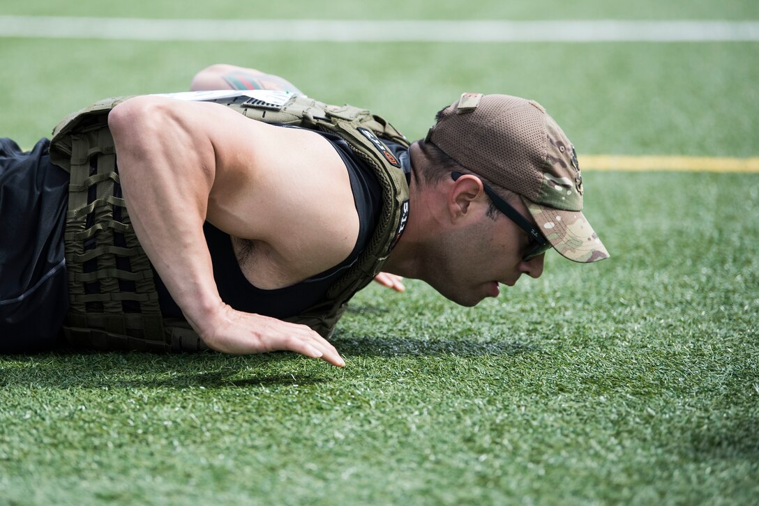 Tech. Sgt. Paul Olmos, 30th Security Forces Squadron military working dog section NCO in charge, performs pushups during the Police Week Warrior Workout of the Day Challenge May 16, 2019, at Vandenberg Air Force Base, Calif. Each competing team of two sprinted between eight workout stations, comprised of various style gym equipment and functional movements while wearing a level-4 plate carrier and had 17 minutes to complete the course. (U.S. Air Force photo by Airman 1st Class Hanah Abercrombie)
