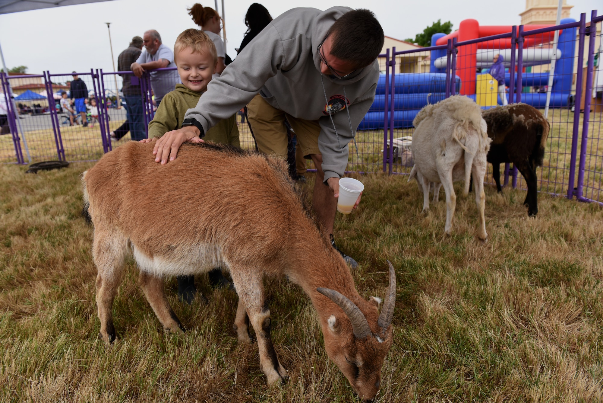 U.S. Air Force Senior Airman Alexander Rivera, 821st Contingency Response Squadron aerial porter, and his son, Liam Rivera, pet a goat during the California Dreaming Spring Block Party May 18, 2019, at Travis Air Force Base, California. The 60th Air Mobility Wing chaplain’s office hosts quarterly block parties to promote goodwill and camaraderie among Travis Airmen and their families. (U.S. Air Force photo by Airman 1st Class Cameron Otte)