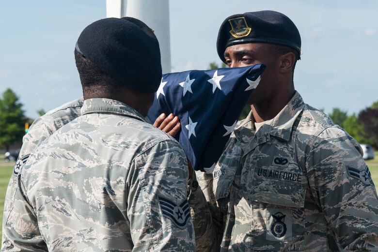 Members of the 633rd Security Forces Squadron honors the United States flag during the closing ceremony of Police Week at Joint Base Langley-Eustis, Virginia, May 17, 2019. During the week, members of the 633rd SFS participated in numerous events, aimed at honoring law enforcement across the country. (U.S. Air Force photo by Airman 1st Class Marcus M. Bullock)