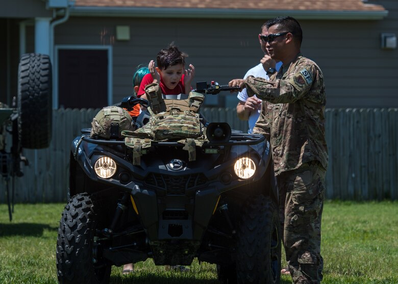 U.S. Air Force Master Sgt. Nicanor Blaustein, 633rd Security Forces Squadron flight chief, shows families of the community how to turn on an All-Terrain Vehicle at Bethel Manor, Hampton, Virginia, May 18, 2019. Families in the community were welcomed to see, sit on and turn on various vehicles. (U.S. Air Force photo by Senior Airman Anthony Nin Leclerec)