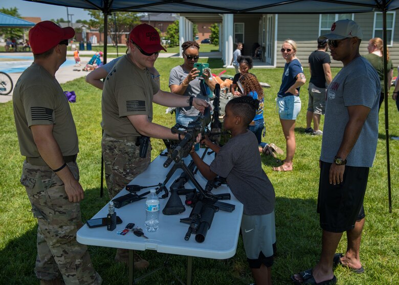 U.S. Air Force combat arms instructors from the 633rd Security Forces Squadron, conduct a weapons display at Bethel Manor, Hampton, Virginia, May 18, 2019. Families in the community were welcome to ask questions about the different weapons on display and feel their weight.  (U.S. Air Force photo by Senior Airman Anthony Nin Leclerec)