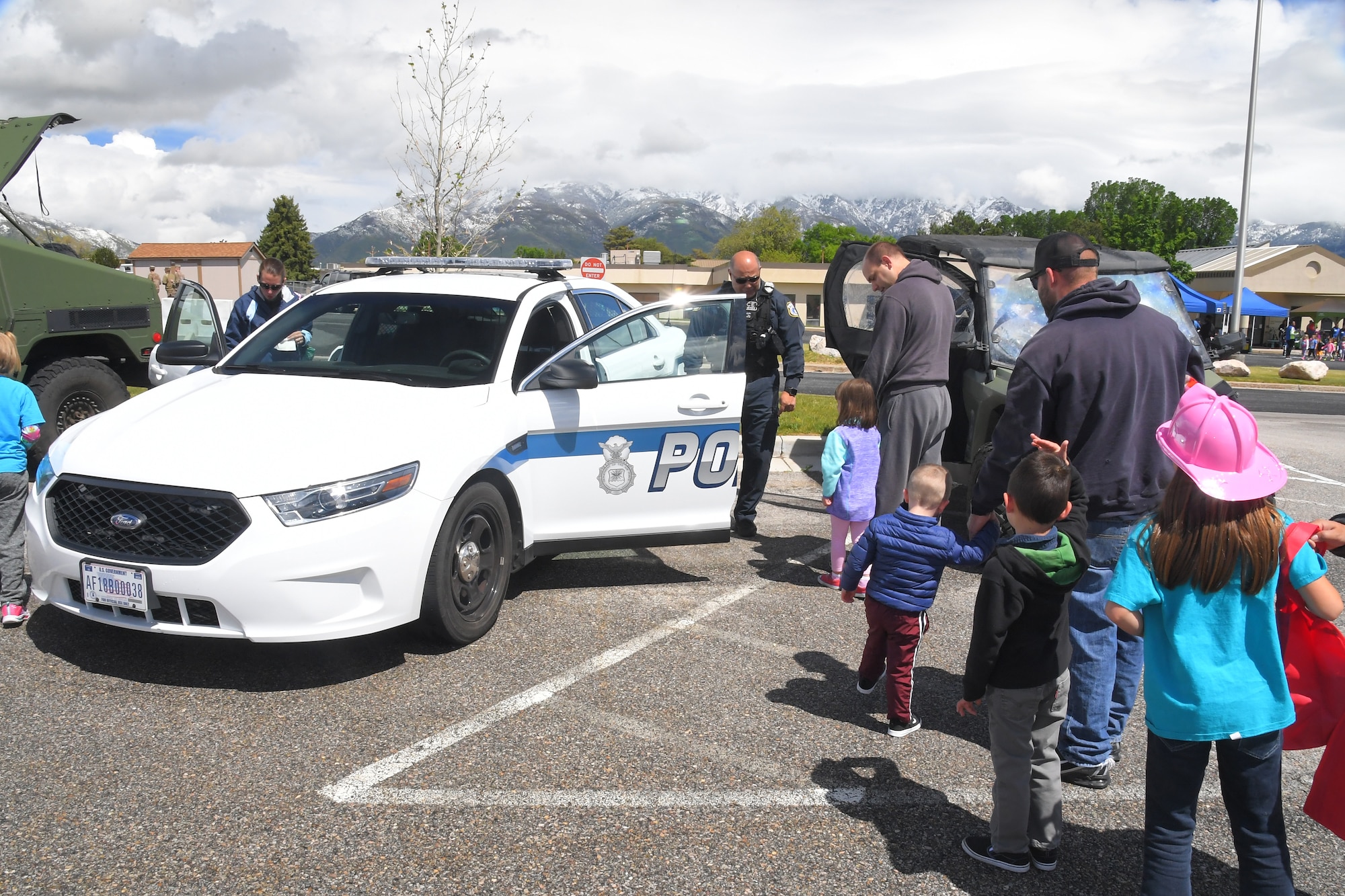 Roland Alforque, 75th Security Forces, shows children the inside of a police car, at the Wheels of Wonder event, May 17, 2019, Hill Air Force Base, Utah. (U.S. Air Force photo by Todd Cromar)