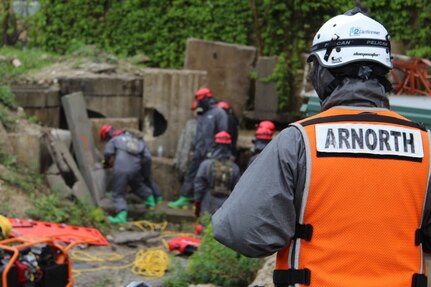 An Army North Observer, Controller, Trainer evaluates Soldiers from 68th Engineer Construction Company, Task Force Operations, Joint Task Force-Civil Support, or JTF-CS, conducting urban search and rescue tasks during Exercise Guardian Response at Muscatatuck Urban Training Center in Indiana May 4. When directed, JTF-CS provides command and control of the 5,200-person Defense Chemical Biological Radiological Nuclear (CBRN) Response Force (DCRF) during a catastrophic crisis in support of civil authorities and the lead federal agency. Vibrant Response/Guardian Response is an annual combined Command Post Exercise and Field Training Exercise which validates the ability of the DCRF forces to conduct the CBRN Response mission.