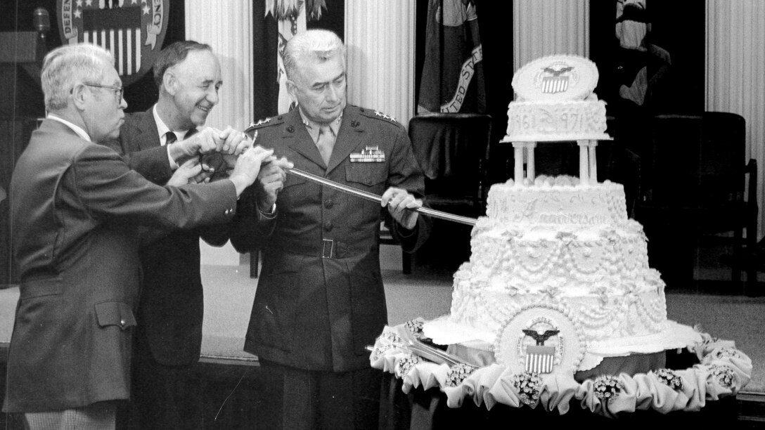 Former Defense Supply Agency directors Army Lt. Gen. Andrew T. McNamara, Navy Vice Adm. Joseph M. Lyle and Marine Lt. Gen Wallace H. Robinson, Jr. cut a cake