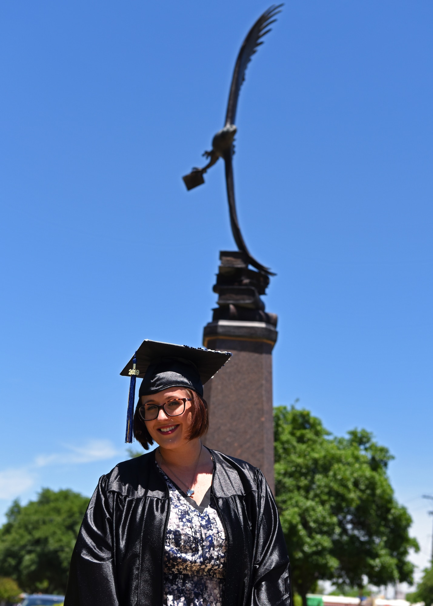 U.S. Air Force Staff Sgt. Britteny Griffith, a 316th Training Squadron linguist instructor at Goodfellow Air Force Base, poses for a portrait next to a statue of an eagle on Angelo State University in San Angelo, Texas, May 8, 2019. Griffith has been studying at ASU for three months as a full time student. (U.S. Air Force photo by Airman 1st Class Ethan Sherwood/Released)