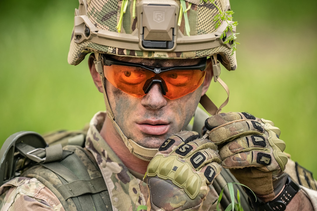 A soldier tightens a helmet on before a competition.