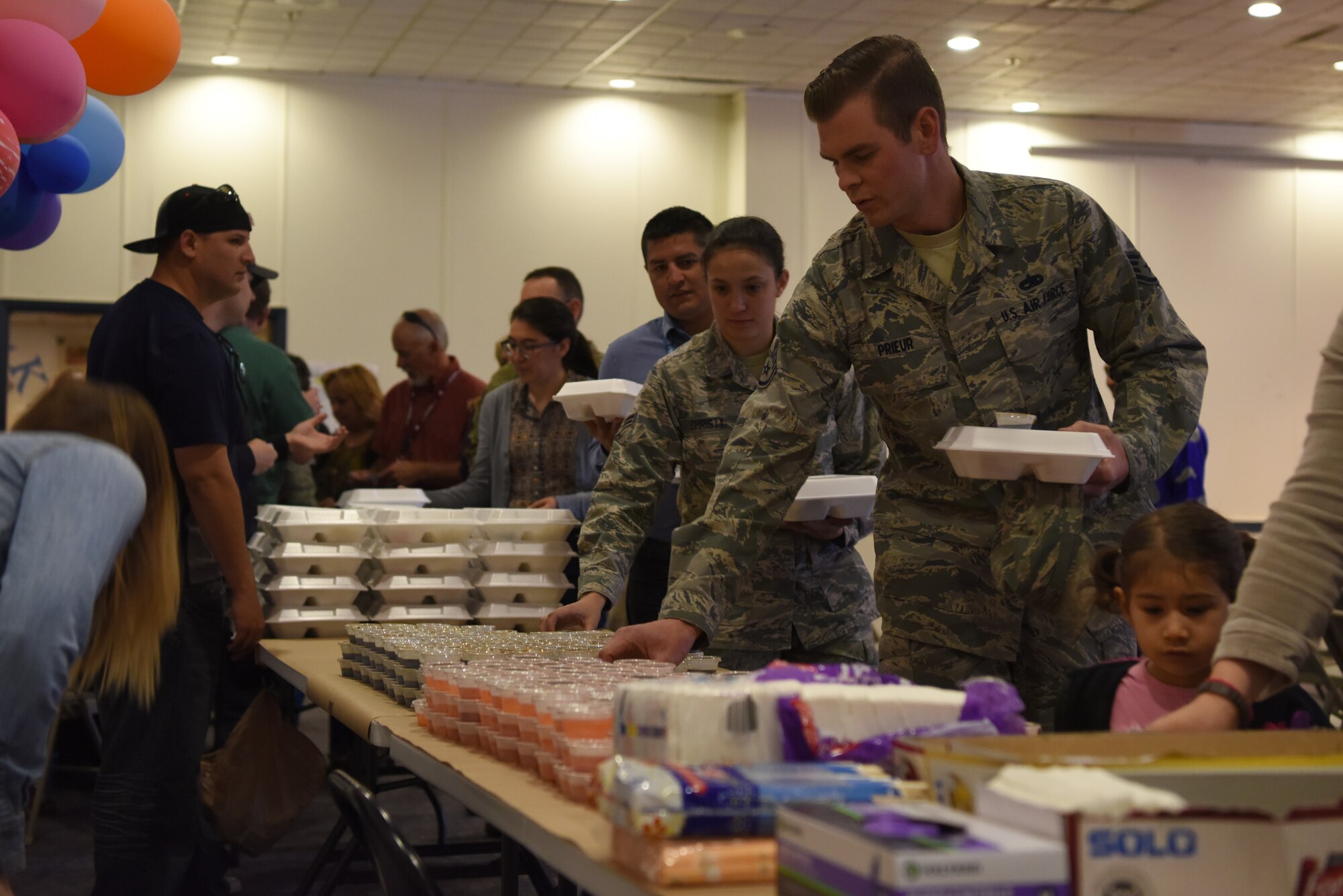 Attendees of the Asian-American Pacific Islander Heritage Cultural Show and Luncheon recieve their food at Kirtland Air Force Base, N.M., May 22, 2019. The meal included grilled beef, lumpia and kalua pork. (U.S. Air Force photo by Senior Airman Eli Chevalier)