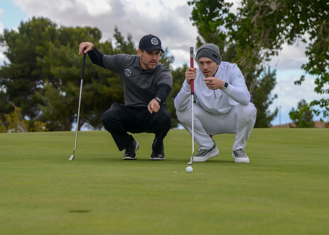 U.S. Marshal Zack Tyler and Joey Gonzalez discussing putting strategy during a golf tournament during Police Week, at Edwards Air Force Base, California, May 14. Police Week is observed May 13-17. (U.S. Air Force photo by Giancarlo Casem)