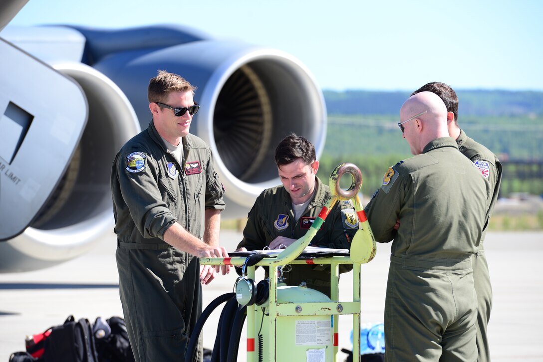 Four U.S. Air Force 909th Air Refueling Squadron Airmen discuss flight plans during exercise Northern Edge, May 16, 2019, at Eielson Air Force Base, Alaska.