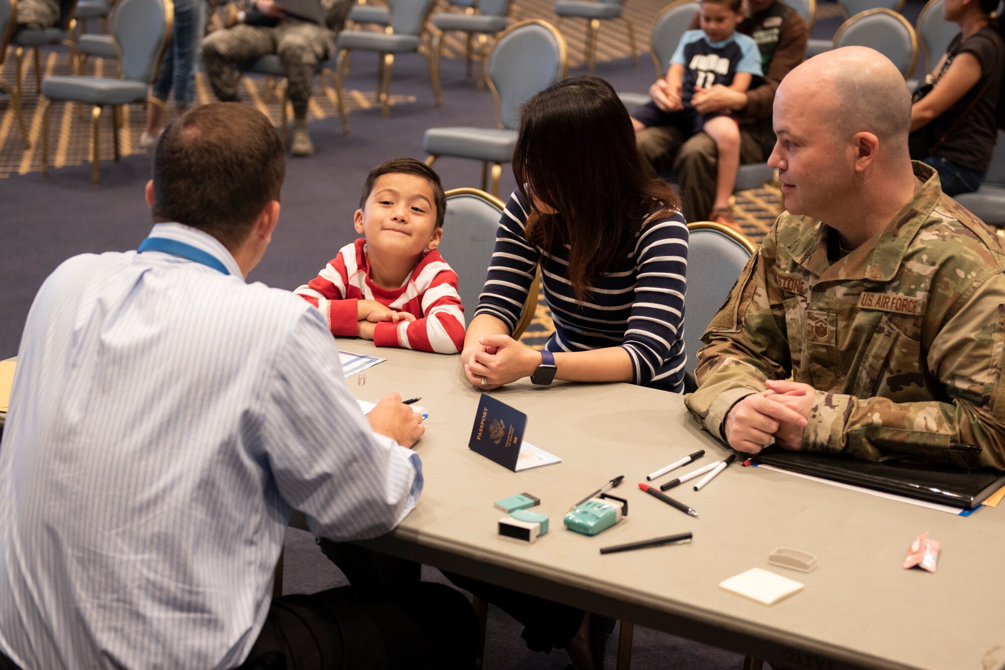 A United States Embassy employee shares a moment with a boy and his family applying for a Passport at United States Embassy Outreach event at Yokota Air Base, Japan, May 22, 2019.