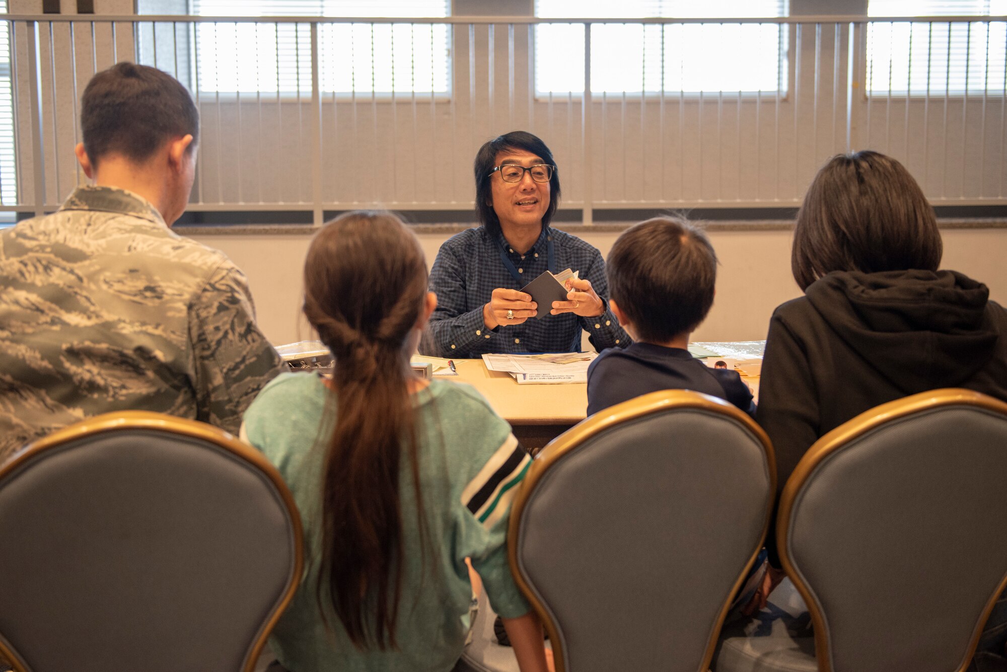 A United States Embassy employee discusses the Passport application process with a family at a United States Embassy Outreach event at Yokota Air Base, Japan, May 22, 2019.