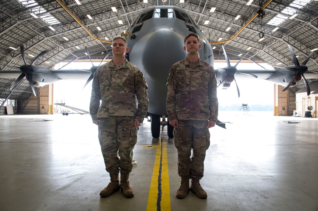 Col. Todd Wydra, 374th Maintenance Group commander (left), and Master Sgt. James Charles, 374th Aircraft Maintenance Squadron production superintendent, stand at attention