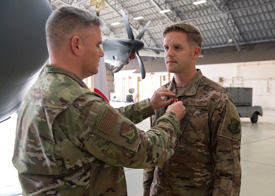 Col. Todd Wydra, 374th Maintenance Group commander, pins a Bronze Star Medal on Master Sgt. James Charles