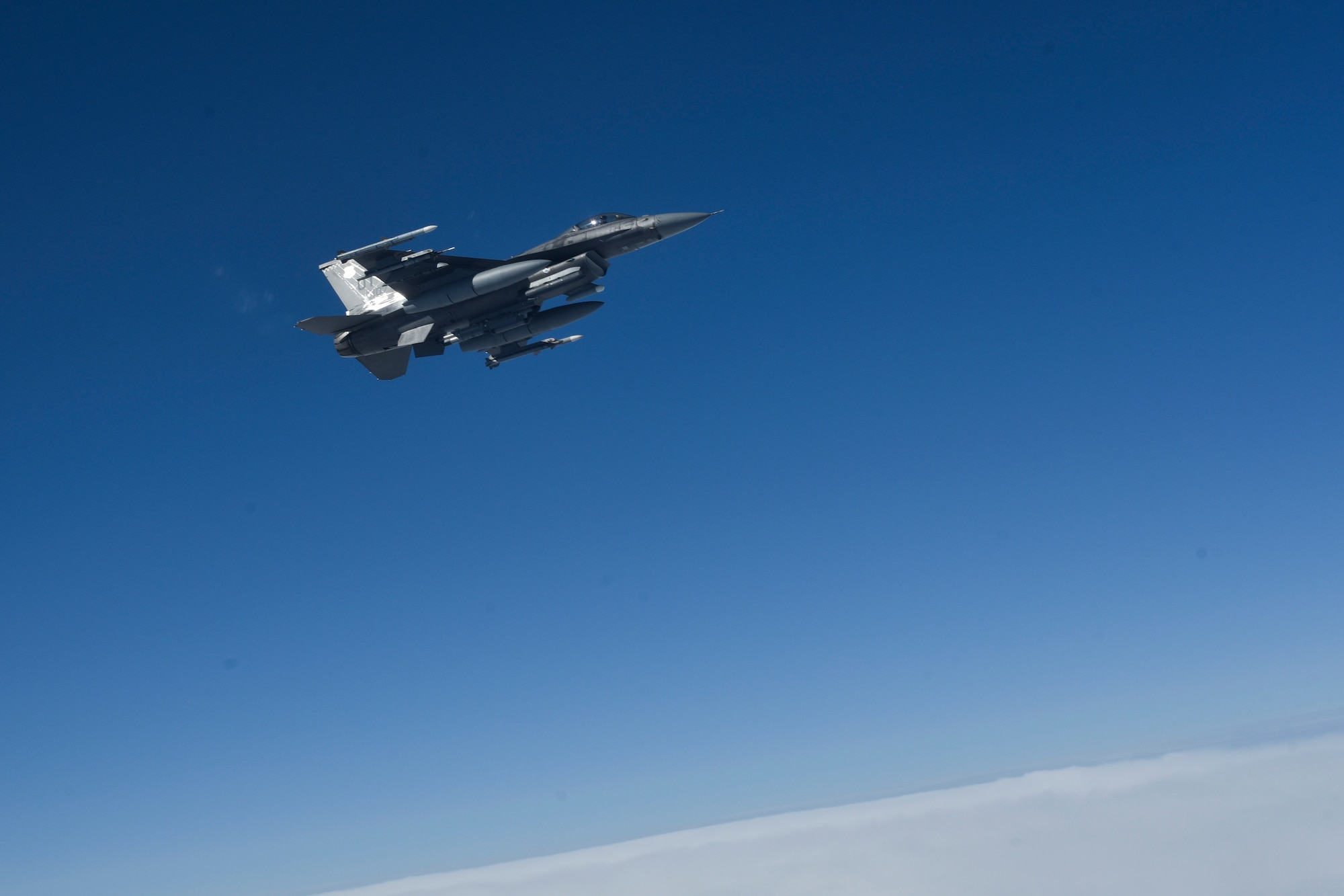 A U.S. Air Force F-16C Fighting Falcon flies alongside a 909th Air Refueling Squadron KC-135R Stratotanker after receiving fuel during Northern Edge (NE19), May 16, 2019, over the Gulf of Alaska.
