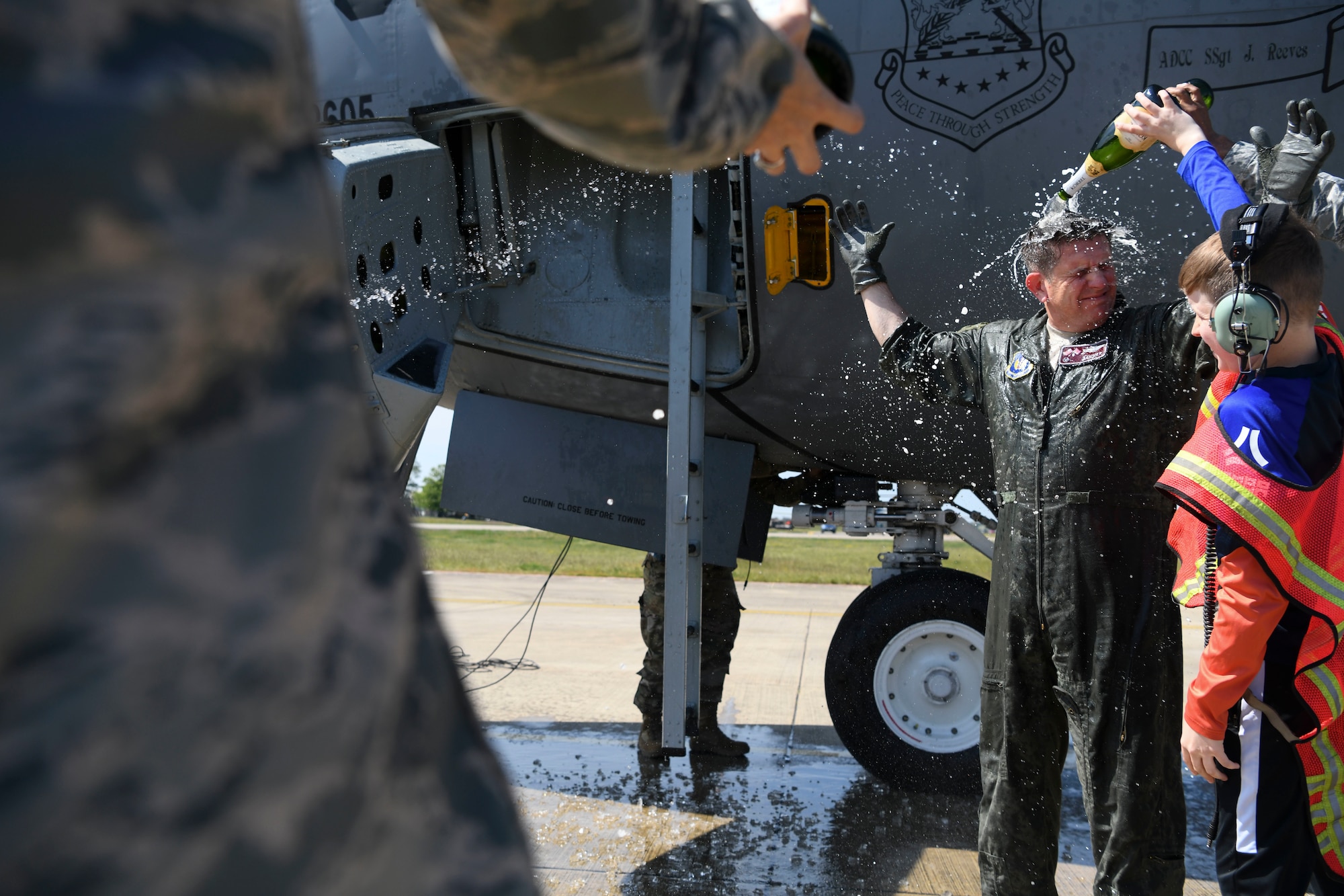 The son of U.S. Air Force Col. Christopher Amrhein, 100th Air Refueling Wing Commander, showers him with champagne to celebrate his final flight as commander of 100th ARW at RAF Mildenhall, England, May 15, 2019. Amrhein celebrated his “fini-flight” following a two-year command with his friends and wing. (U.S. Air Force photo by Senior Airman Alexandria Lee)