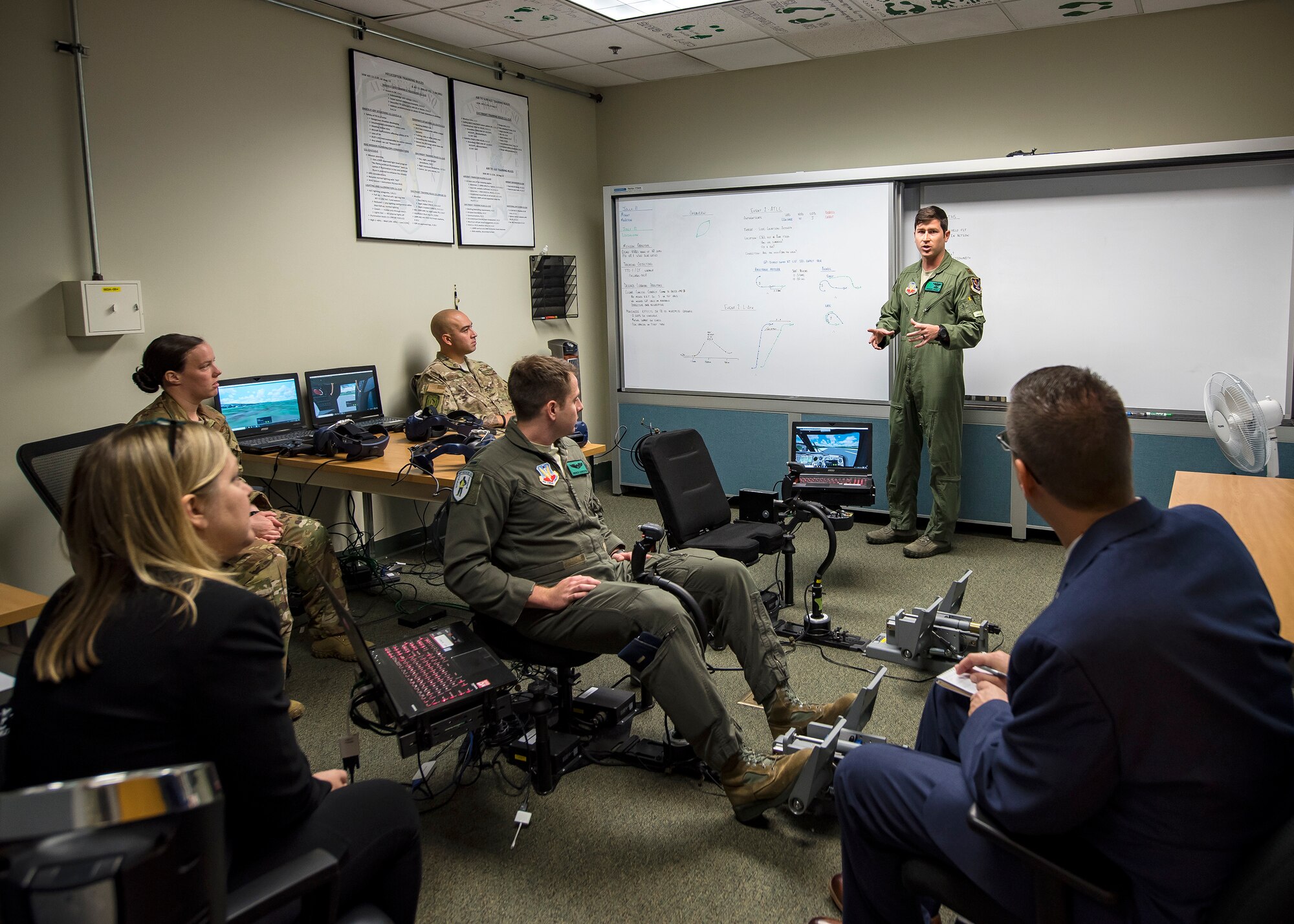 Maj. Patrick Mount, 41st Rescue Squadron (RQS) instructor pilot, briefs science and technology advisors from Air Combat Command, May 16, 2019, at Moody Air Force Base, Ga. Dr. John Matyjas and Dr. Donna Joyce visited the 41st RQS to tour and assess their Virtual Reality flight simulator. The visit is a part of an Air Force assessment of the possible implementation of VR in training. The 41st RQS VR flight simulator is an initiative that was selected at the Moody Air Force Base 2018 Spark Tank competition. (U.S. Air Force photo by Airman 1st Class Eugene Oliver)