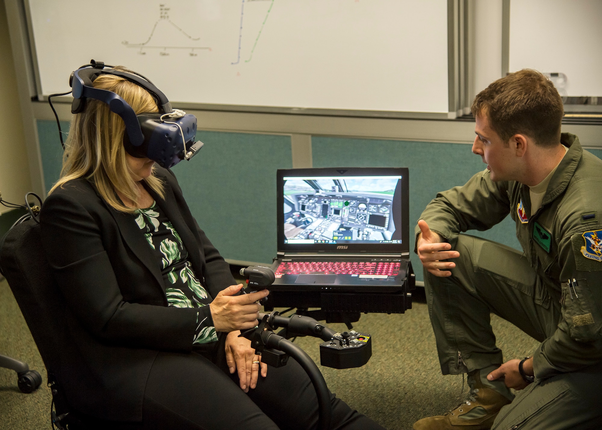 1st Lt. Patrick Livingston, 41st Rescue Squadron (RQS), HH-60G Pave Hawk co-pilot, gives instruction on their virtual reality flight simulator to Dr. Donna Joyce, science and technology advisor to Air Combat Command, May 16, 2019, at Moody Air Force Base, Ga. Dr. John Matyjas and Joyce visited the 41st RQS to tour and assess their VR simulator along with taking a fam flight on an HH-60G Pave Hawk. The visit is a part of an Air Force assessment of the possible implementation of VR in training. The 41st RQS VR flight simulator is an initiative that was selected at the Moody Air Force Base 2018 Spark Tank competition. (U.S. Air Force photo by Airman 1st Class Eugene Oliver)