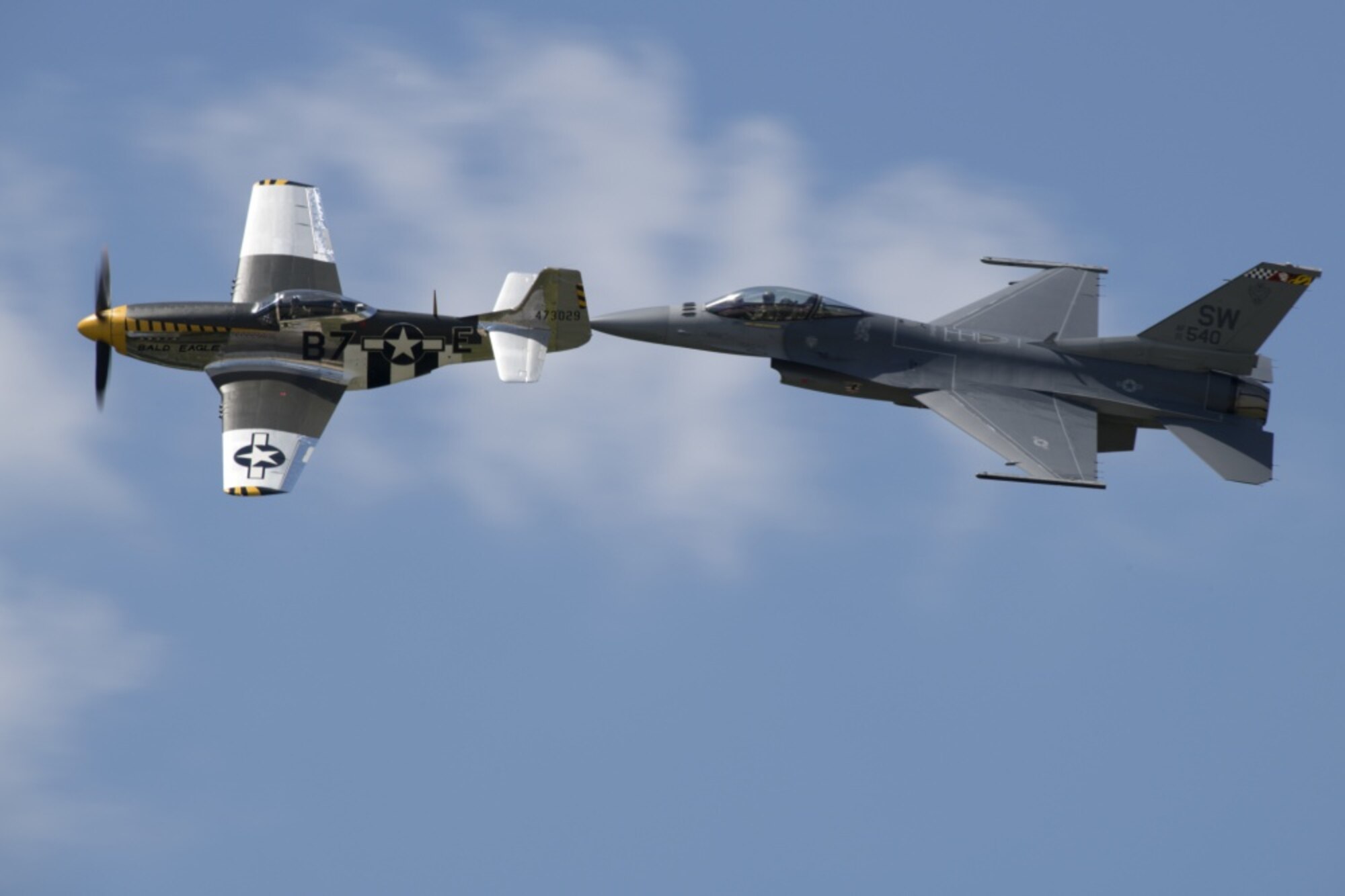 U.S. Air Force Maj. Garret Schmitz, F-16 Viper Demonstration Team commander and pilot, right, and Jim Beasley, Air Force Heritage Flight Foundation P-51 pilot, fly in formation during training at Joint Base Langley-Eustis, Virginia, May 16. Schmitz is scheduled to participate in Heritage Flights around the world throughout the 2019 and 2020 performance seasons. (U.S. Air Force photo/Senior Airman Kathryn R.C. Reaves)