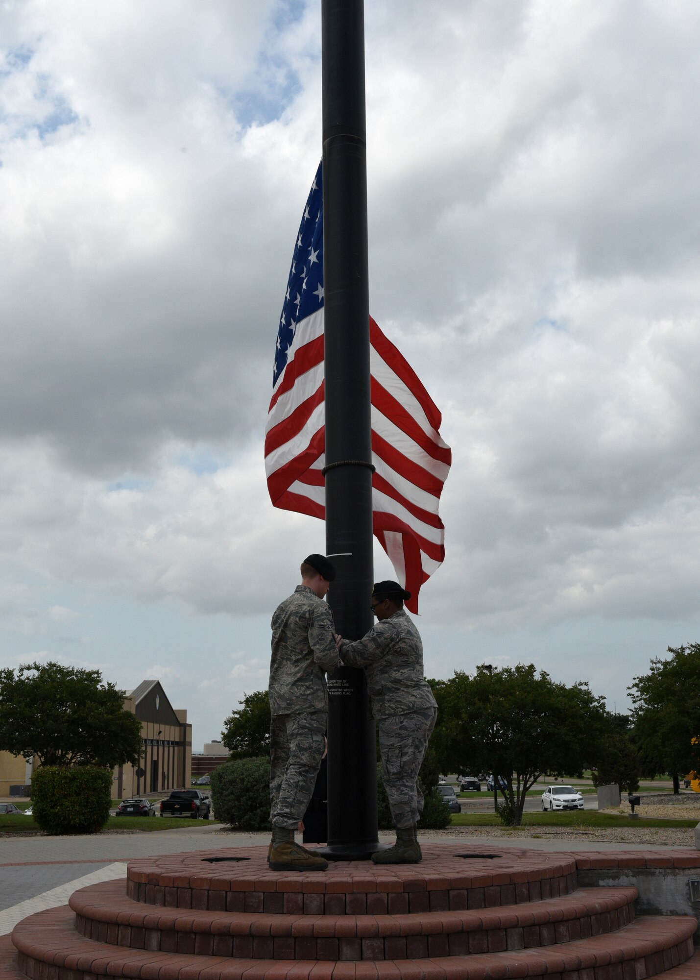 U.S. Air Force Senior Airman Dianiche Baxton and Airman 1st Class Ian Moran from the 17th Security Forces Squadron lower the flag during the special Retreat Ceremony, signifying the end of Police Week on Goodfellow Air Force Base, Texas, May 17, 2019. Police Week was established by President John F. Kennedy in 1962. (U.S. Air Force photo by Airman 1st Class Robyn Hunsinger/released)