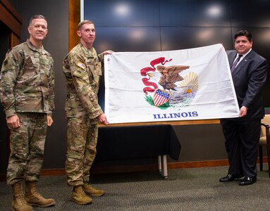 Illinois Governor JB Pritzker presents an Illinois flag to Chief Warrant Officer 5 Jason Stiff of Pawnee, Illinois, Commander, Detachment 5, Company A, 2nd Battalion, 245th Aviation Regiment, during the mobilization ceremony May 22 at Camp Lincoln, Springfield, Illinois. The unit will deploy to the Horn of Africa. Joining Pritzker and Stiff is Illinois Adjutant General Brig. Gen. Richard Neely. (U.S. Army photo by Barbara Wilson, Illinois National Guard Public Affairs Office.)