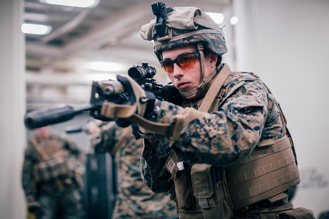 A Marine aims a rifle.
