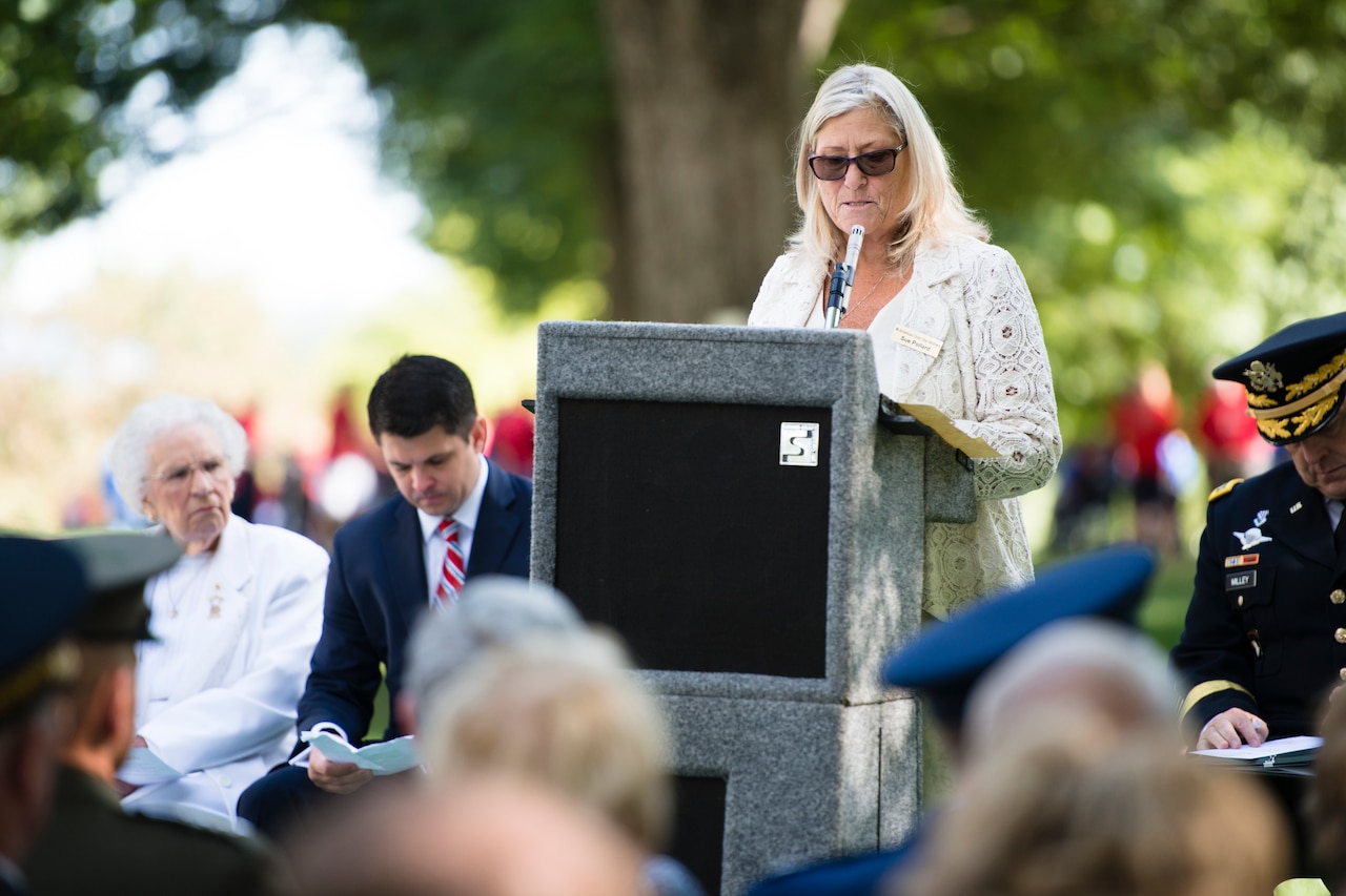 A woman speaks at lectern.