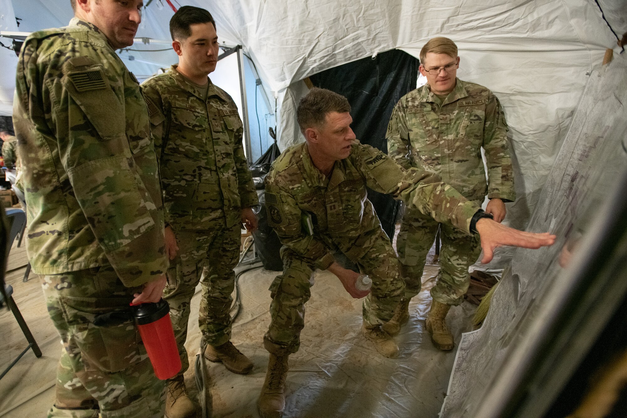 Oklahoma Air National Guard Capt. Trevor Smith, the brigade air liaison officer assigned to the 146th Air Support Operations Squadron, traces troop movements and points out targets on a map to other 146th ASOS Airmen during a brigade Warfighter exercise (WFX 19-12) held at Camp Ripley near Little Falls, Minn., May 12, 2019. The 24-hour continuous, graded exercise, which is the second of three exercises that U.S. Army and National Guard units are required to complete before deployment, tests the units at the brigade level before heading to the final and more applied exercise at the National Training Center (NTC), in Fort Irwin, Calif. (U.S. Air National Guard photo by Tech. Sgt. Kasey M. Phipps)