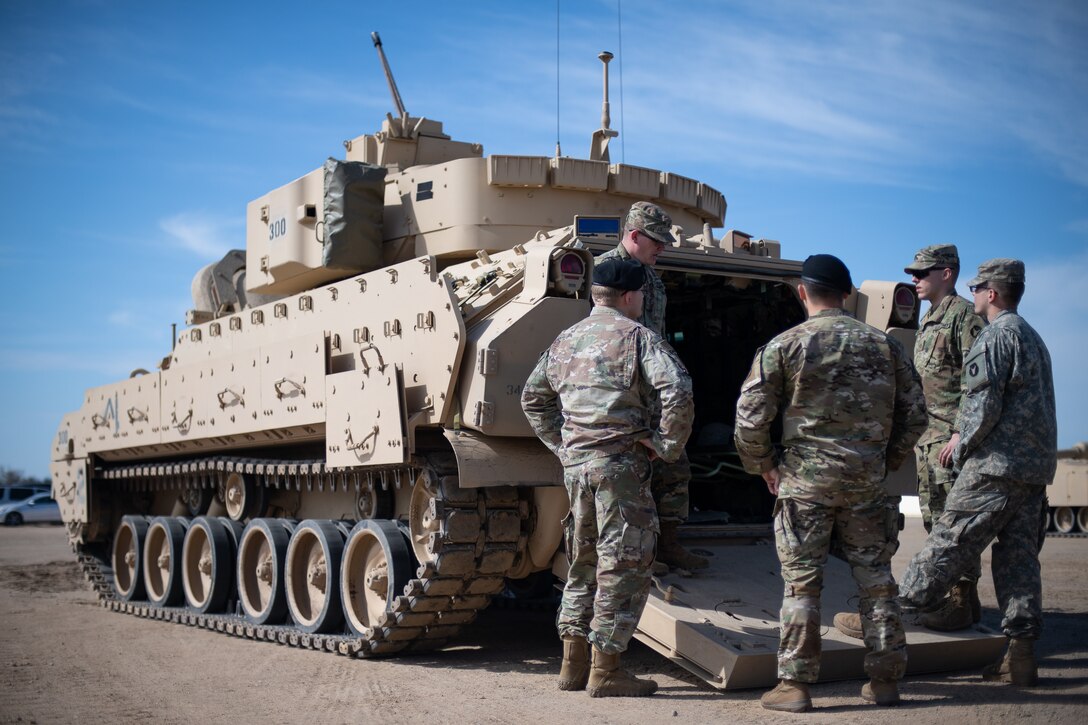 Minnesota Army National Guardsmen infantrymen with the Headquarters and Headquarters Company, 1st Combined Arms Battalion, 194th Armor Regiment, 1st Armored Brigade Combat Team, 34th Infantry Division, talk to Oklahoma Air National Guardsmen from the 146th Air Support Operations Squadron (146th ASOS) about the capabilities and space available for communication equipment in a nearby M2 Bradley Fighting Vehicle during a brigade Warfighter exercise (WFX 19-12) held at Camp Ripley near Little Falls, Minn., May 13, 2019. The 24-hour continuous, graded exercise, which is the second of three exercises that U.S. Army and National Guard units are required to complete before deployment, tests the units at the brigade level before heading to the final and more applied exercise at the National Training Center (NTC), in Fort Irwin, Calif. (U.S. Air National Guard photo by Tech. Sgt. Kasey M. Phipps)