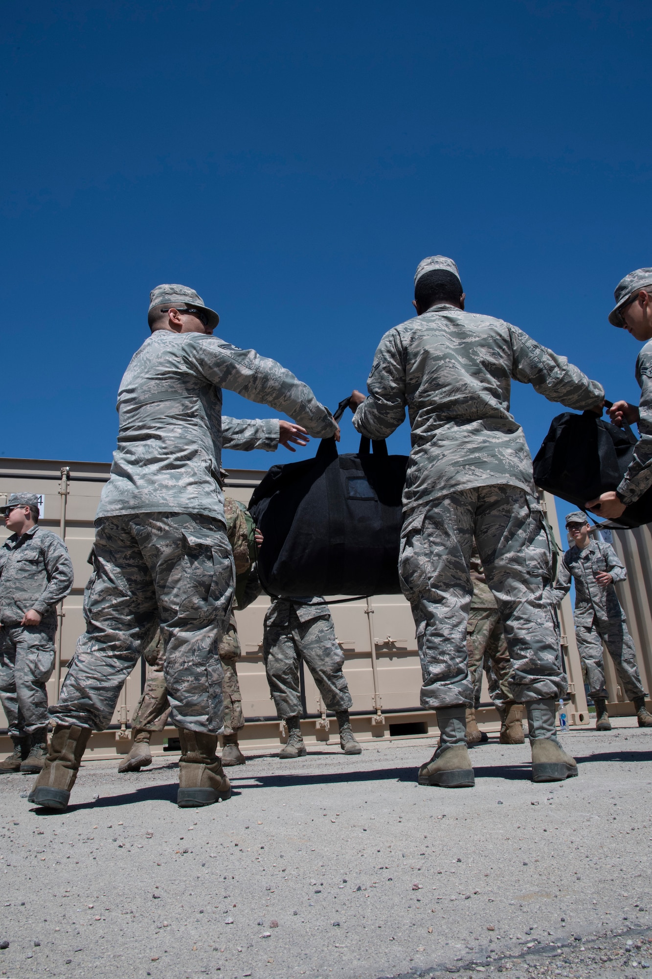 Grand Forks Air Force Base airmen work together to unload personal belongings and mission oriented protective posture gear May 20, 2019, to be used during exercise Summer Viking 19-01 on the National Air Guard Base in Fargo, North Dakota. Participants operated from a simulated contested base, in order to test capabilities and readiness in a deployed environment. (U.S. Air Force photo by Senior Airman Elora J. Martinez)