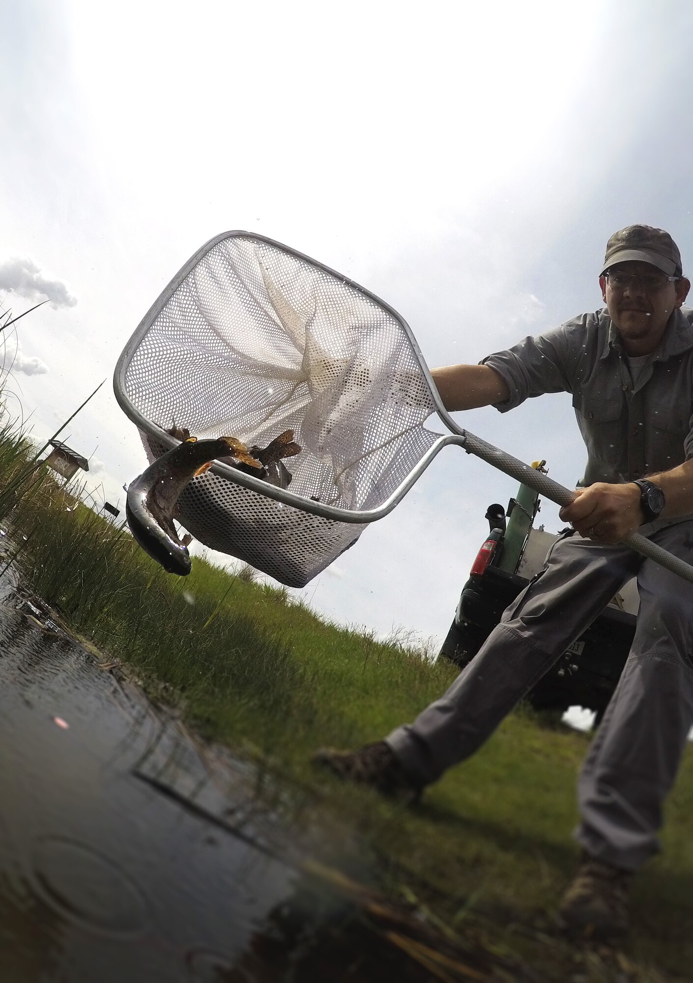Jerick Graves, Montana Department of Fish, Wildlife and Parks fish culture specialist, stocks Powwow Pond with rainbow trout May 22, 2019, at Malmstrom Air Force Base, Mont.