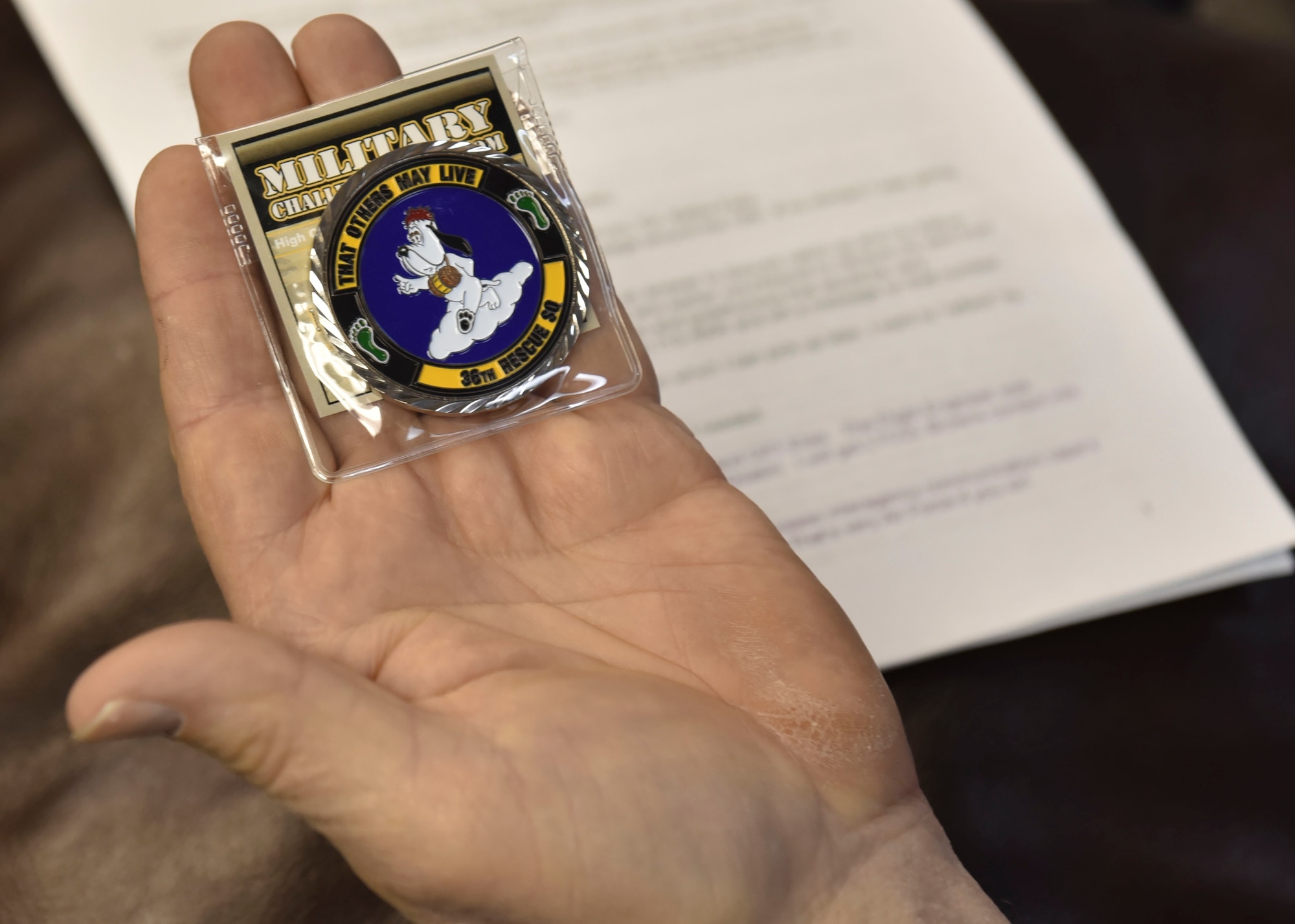 Karl Shoemaker holds a 36th Rescue Squadron coin